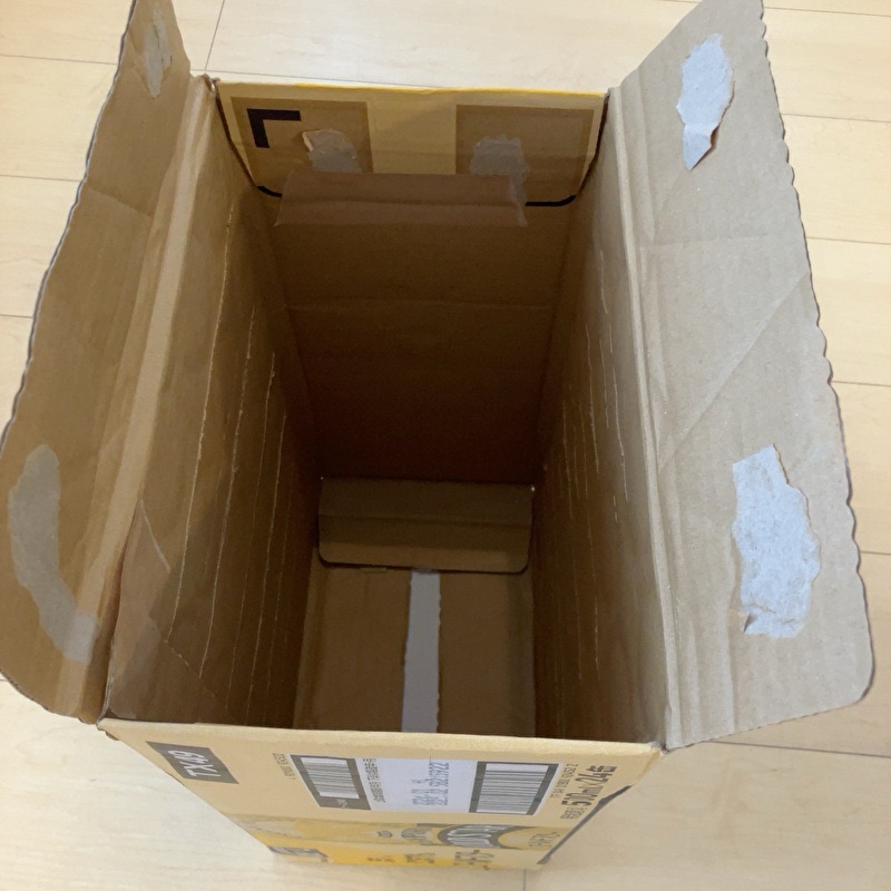 段ボール上部のふた部分を内側に折りガムテープで固定している