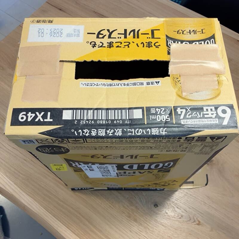 つぶした状態の段ボール箱を立体にしてガムテープで留めている
