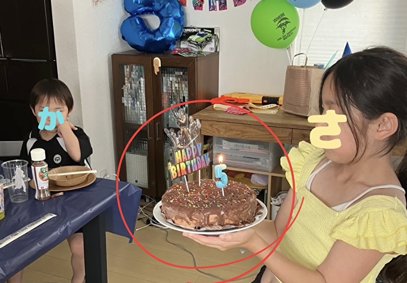 女の子が手作りのバースデイケーキを持っている所