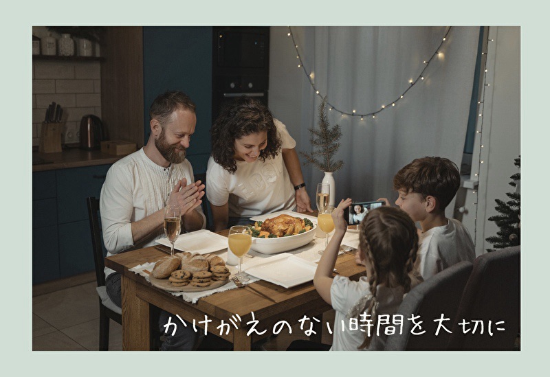 家族で料理を囲み乾杯する画像