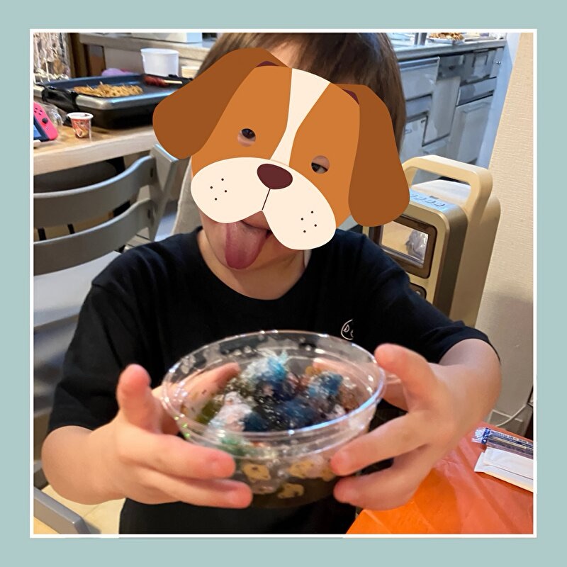 全種類をかけたかき氷を見せようとする男の子