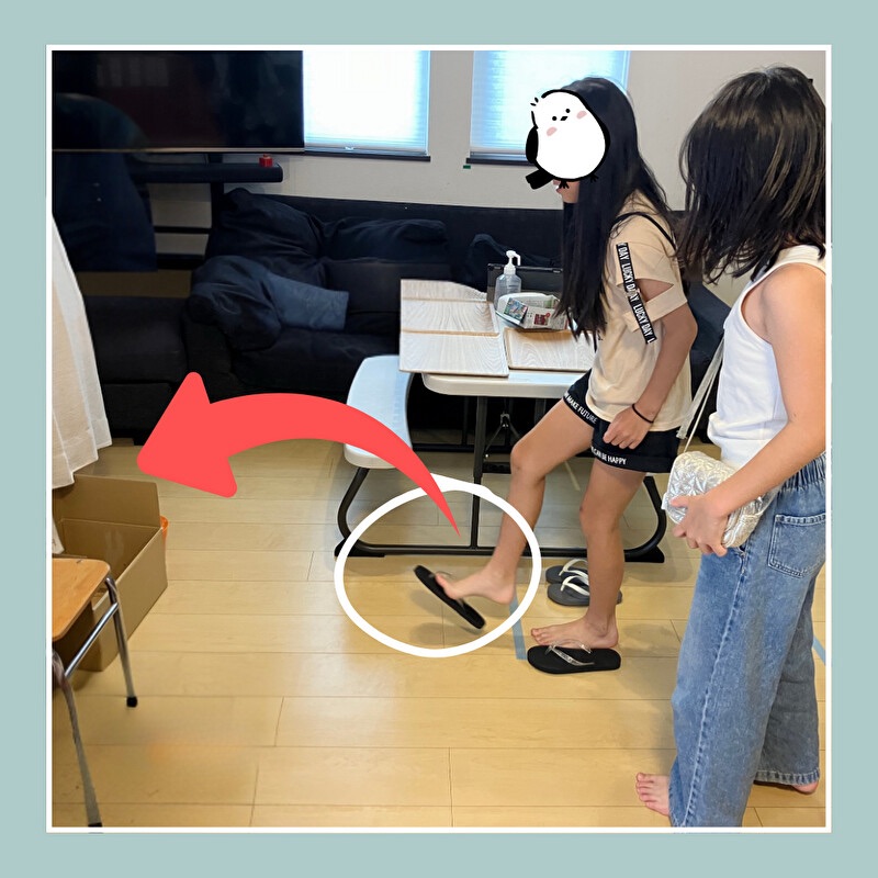 サンダルを足で投げ入れようとしている女の子