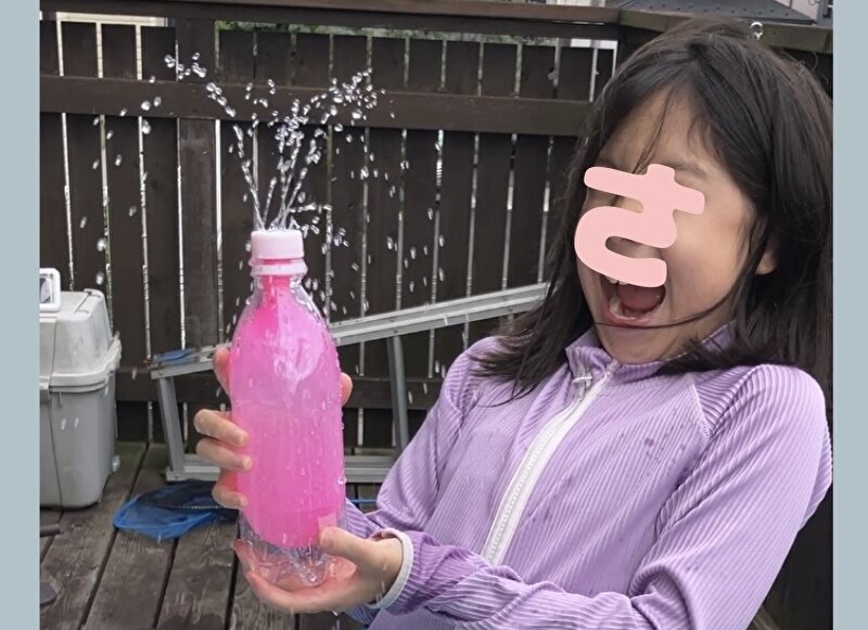 ペットボトルの手作り噴水で遊ぶ女の子